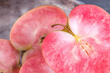 Pink and red fleshed apples on a dark background. Apples with pink flesh