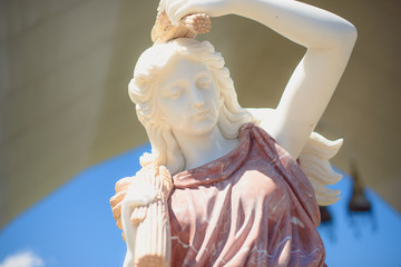 The statue of the Greek goddess. Portrait of a statue of a woman against the sky. Sculpture of an...