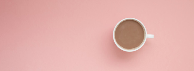 Cup of coffee with milk on pink background