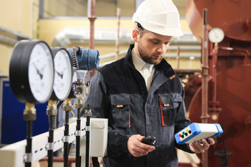 Technician operator measuring value of pressure, temperature and flow on gas and oil processing...