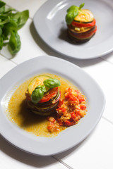 ratatouille healthy veggie traditional recipe on white wooden background with basil leaves