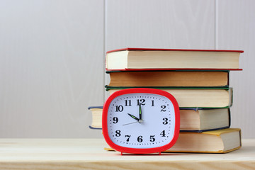 Clock and books on the table. Empty space for Your text.