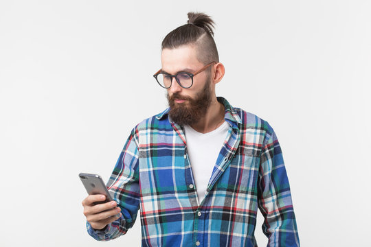 Technologies, fashion and people concept - Cool man with beard using telephone over white background