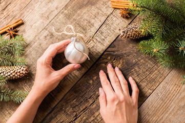 Young woman decorating the Christmas tree, cone