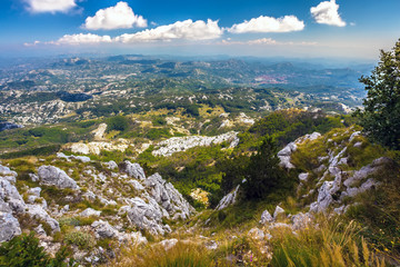 Fototapeta na wymiar Panoramic view of a mountain valley near the town of Cetinje on a summer sunny day from the top of the mountain. Vidikovac, Lovcen National Park, Montenegro.