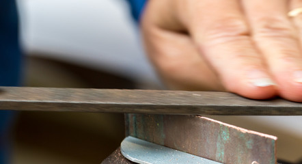 filing a piece of copper