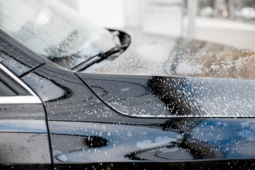 Close-up of a clean car with water dropes after the washing