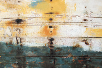 Old abandoned wooden ship boat detail plank board panel yellow white blue rusty cracked paint