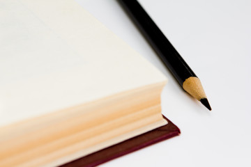 closeup library book with black pencil top view isolated on white background. science and education concept.