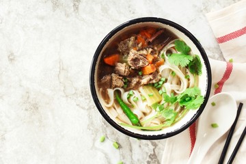 Pho Vietnamse Noodle Soup in a bowl overhead view with copy space
