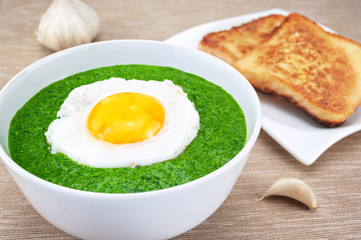 Spinach cream soup with fried egg