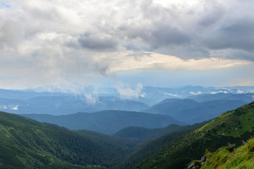 View from the summit to the Carpathian mountains at the bad weather with rain clouds, nature landscape