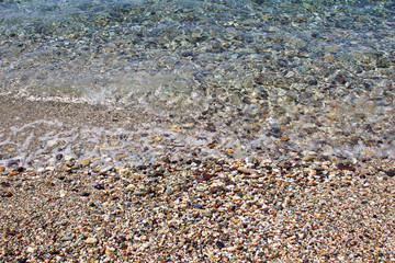 Water sea ocean sand pebbles beach swash wave waterline shallow surface texture clear summer nobody abstract background