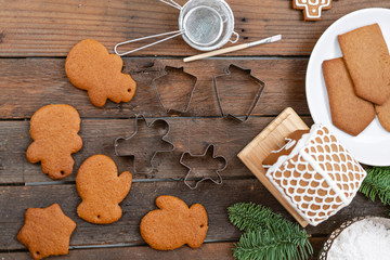 Blank biscuit gingerbread, ready to decorate. Icing of Christmas bakery. Woman decorating honey gingerbread cookies on wooden brown table. closeup, copy space