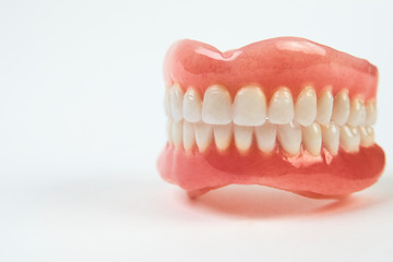 Artificial teeth on a white background with copy space.