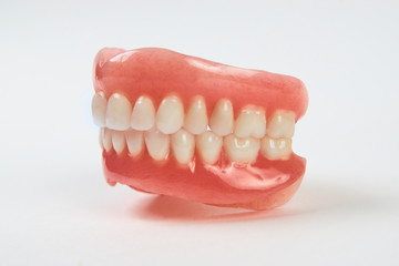 Artificial teeth on a white background with copy space.