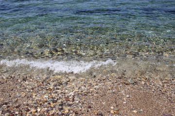 Water sea ocean sand pebbles beach swash wave waterline shallow surface texture clear summer nobody abstract background