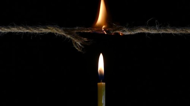 Candle firing rope. Time is up. Open circuit. Torn thread. The end has come. Hand and match ignite a candle.
