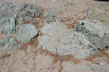 Rocks boulders on beach shore sand grey gray sedimentary detail abstract