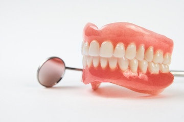 Fototapeta na wymiar Artificial teeth on a white background with copy space.