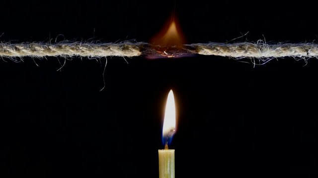 Candle firing rope. Time is up. Open circuit. Torn thread. The end has come. Hand and match ignite a candle.