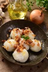 Meat stuffed potato dumplings with fried onion and greaves on top