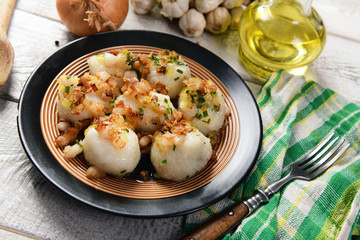 Meat stuffed potato dumplings with fried onion and greaves on top