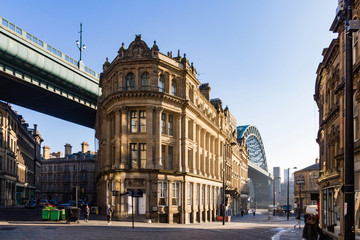 Fototapeta na wymiar Golden light shining on the Tyne Bridge and Georgian buildings on Queen's street in Newcastle Upon Tyne