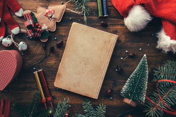 Vintage book among Christmas decoration, flat lay top view