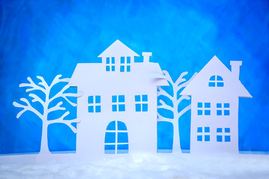 Christmas picture of paper cut houses on a blue background