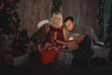 Fototapeta na wymiar Christmas Family Open Present Gift Bag, Looking to Magic Light in Night Xmas Tree loft Interior