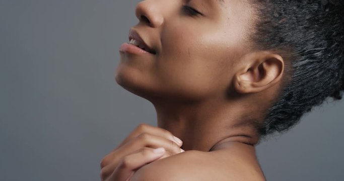 close up portrait beautiful african american woman touching face with hands caressing bare shoulders enjoying smooth healthy skin complexion perfect natural beauty on grey background