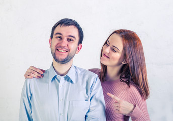 man smiles showing his teeth, the girl shows him her finger and looks at him