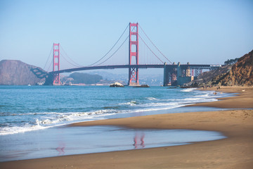 Classic panoramic view of famous Golden Gate Bridge seen from Baker Beach in beautiful summer sunny day with blue sky, San Francisco, California, USA