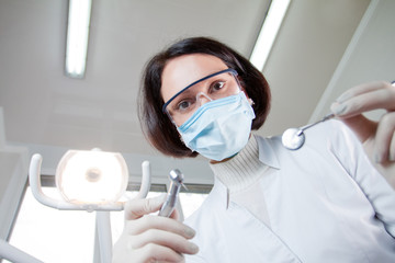 Fototapeta na wymiar Doctor dentist in mask looks at patient