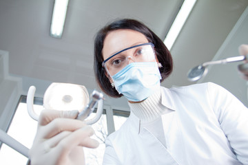 Fototapeta na wymiar Doctor dentist in mask looks at patient
