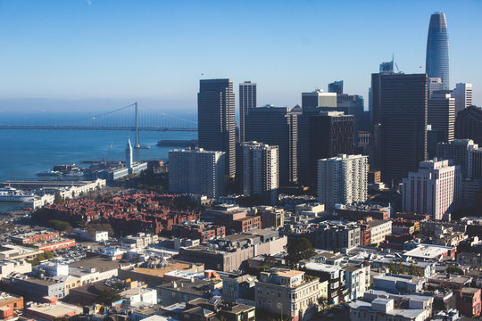 Beautiful super wide-angle aerial view of San Francisco, California, with Bay Bridge, Downtown, Ferry Market, and skyline scenery beyond the city, seen from the observation deck of Coit Tower
