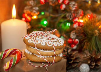 folded Christmas cookies decorated with icing on the background of candles, Christmas trees and garlands