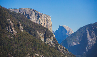 Fototapeta premium Beautiful summer view of Yosemite Valley , with El Capitan mountain, Half Dome mountain, Bridalveil waterfall, seen from Tunnel View vista point, Yosemite National Park, California, USA