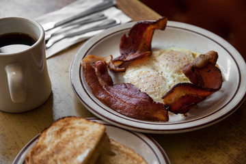 Eggs, bacon and toast with coffee