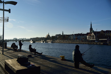 Anglers fishing on the waterfront in Szczecin. - obrazy, fototapety, plakaty