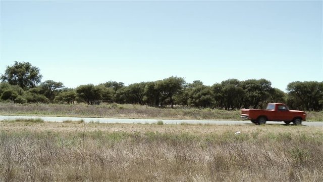 Red Pickup Truck Driving On Country Road / Argentina.