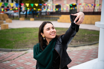 Obraz na płótnie Canvas Happy young woman taking selfie. Woman taking selfie photo with a smarphone in the city.