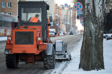 Tractor cleaning the road from the snow. Excavator cleans the streets of large amounts of snow in...