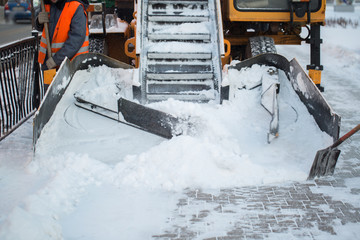 Tractor cleaning the road from the snow. Excavator cleans the streets of large amounts of snow in...