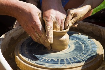 Potter's hands make a clay bowl on a pottery wheel, master teach to make pottery