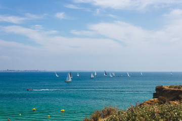 Lots of sailboats sailing in the ocean near the coast of Lagos, Portugal