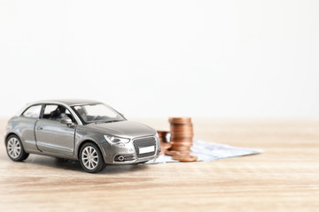 Toy car and money on table, space for text. Vehicle insurance