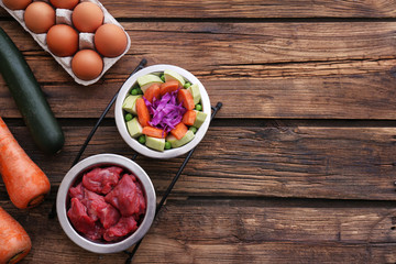 Flat lay composition with healthy dog food on wooden background. Space for text
