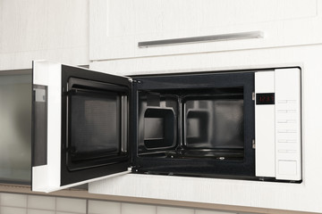 Fototapeta premium Open modern microwave oven built in kitchen furniture